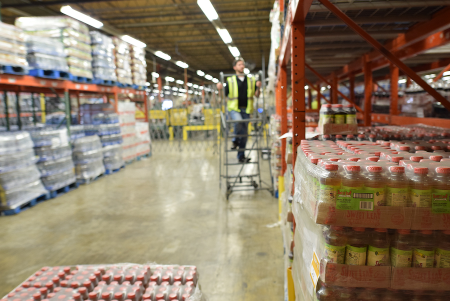 Man on rolling ladder in warehouse